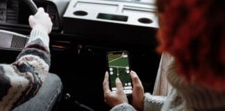 Dwie osoby korzystają z aplikacji nawigacyjnej w smartfonie podczas jazdy