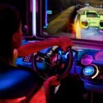 Osoba grająca na immersyjnym symulatorze wyścigowym w neonowym świetle